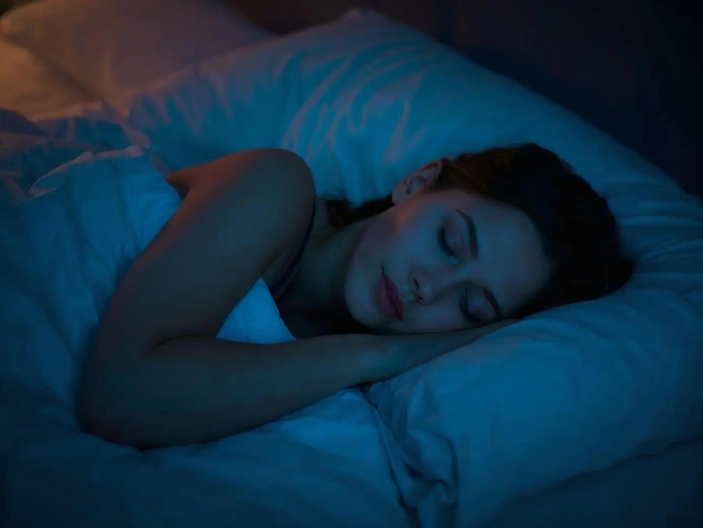 Une jeune femme qui dort paisiblement dans un lit